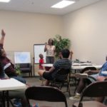 Cadets raise their hands to give an answer during an interactive activity.