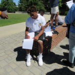 A cadet takes diligent notes outside during a tour of UTC.